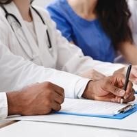Image of people writing at a table