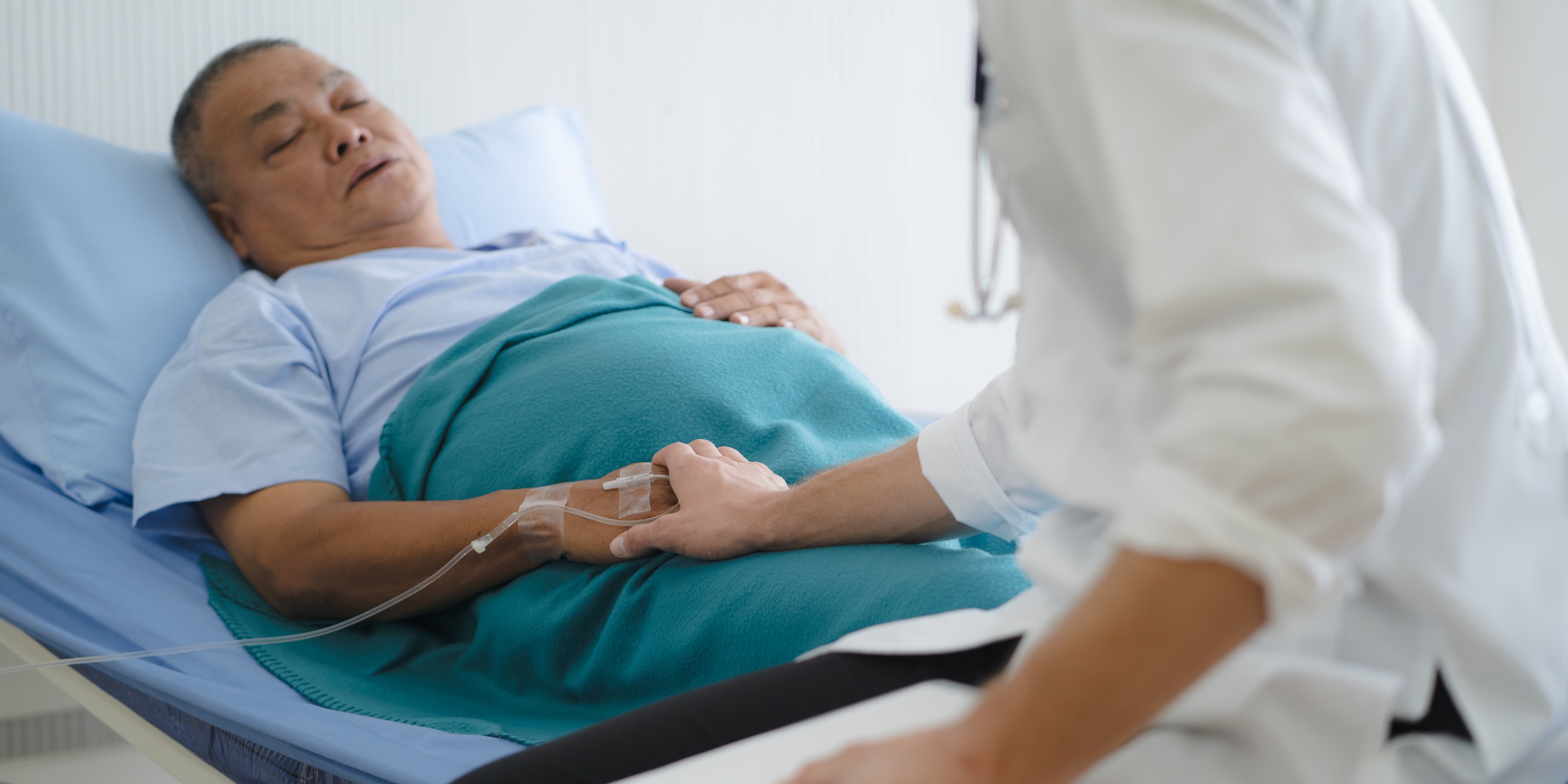 Image of a doctor holding the hand of a sick patient