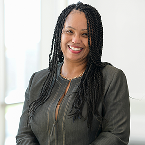  Headshot of Holly Brown wearing a grey top and gold necklace