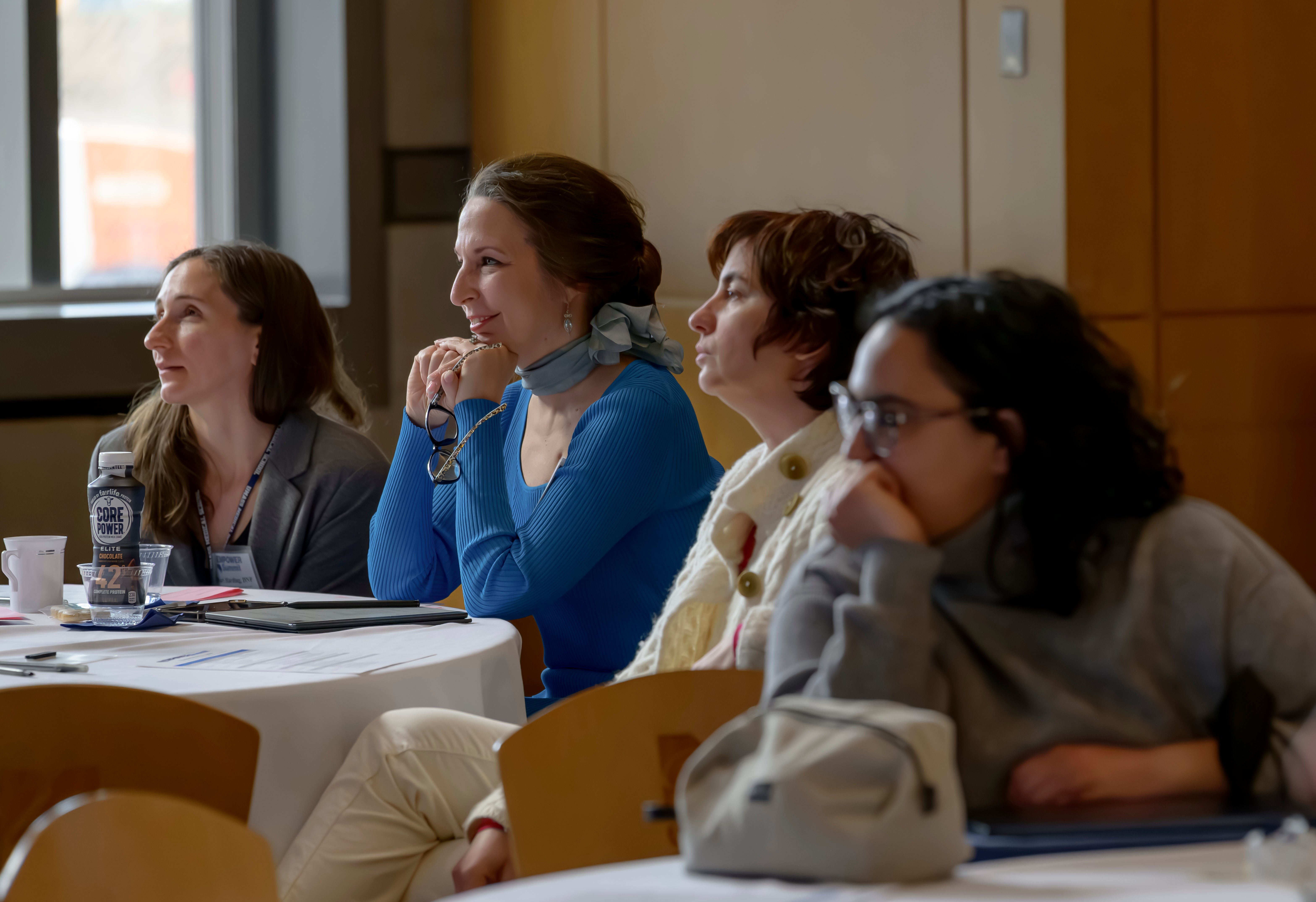 four women listening to a speaker