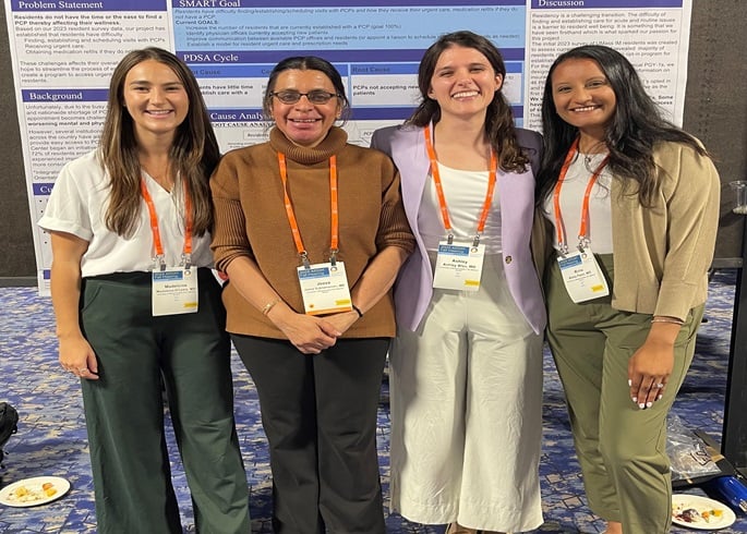 primary care students posing with a poster