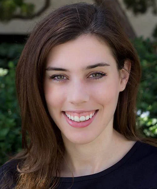 Lily Brown, smiling White woman with brown hair wearing a black top