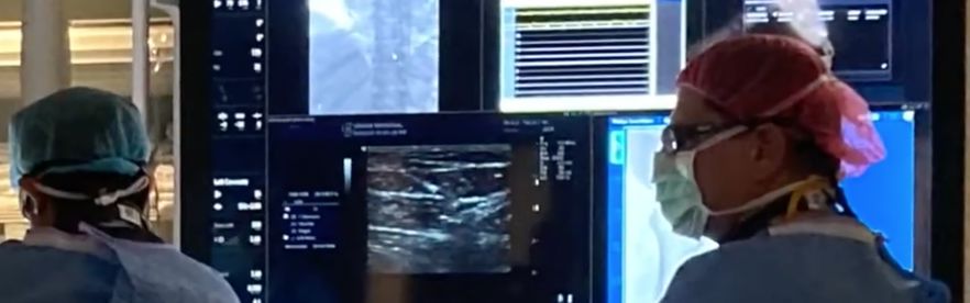 Doctors looking at medical monitors