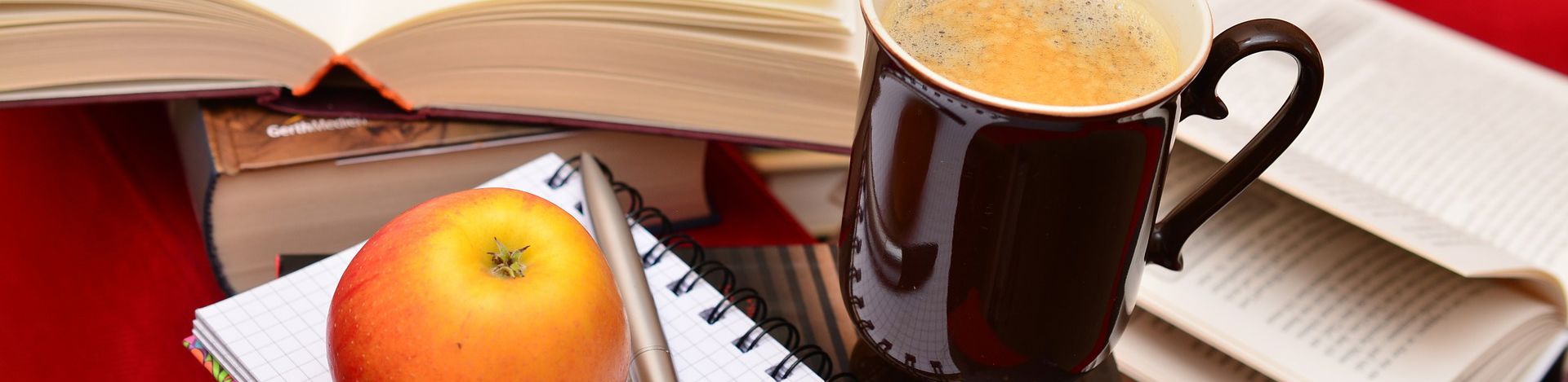 scene with mug of coffee,  book, pen, apple