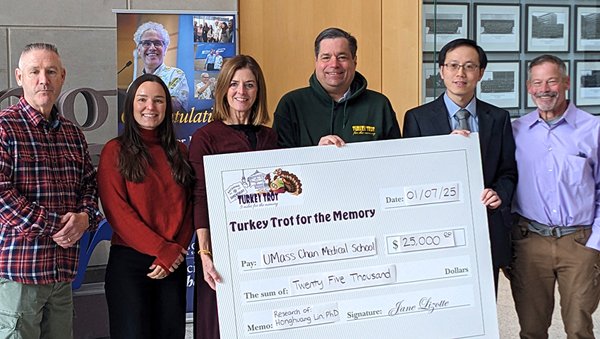 Group of people holding up a giant check.