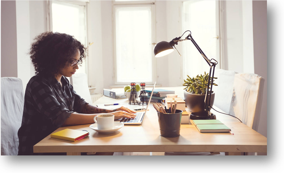 Woman at table working on laptop in sub filled living room