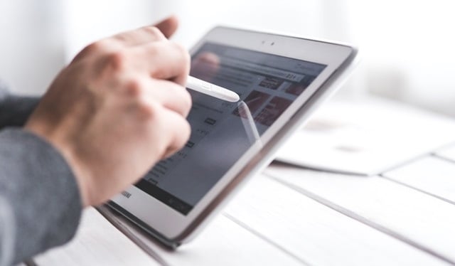 Person writing on tablet device