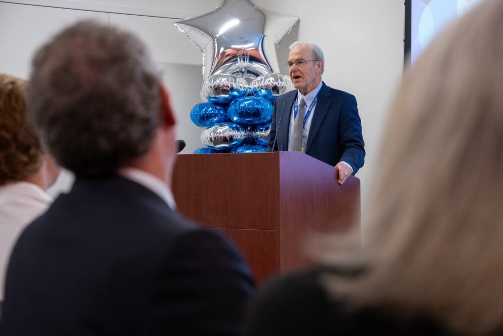 Dean Flotte welcoming the new medical students and thanking them for the opportunity for a shared learning experience. He is at a podium, speaking into a microphone. 