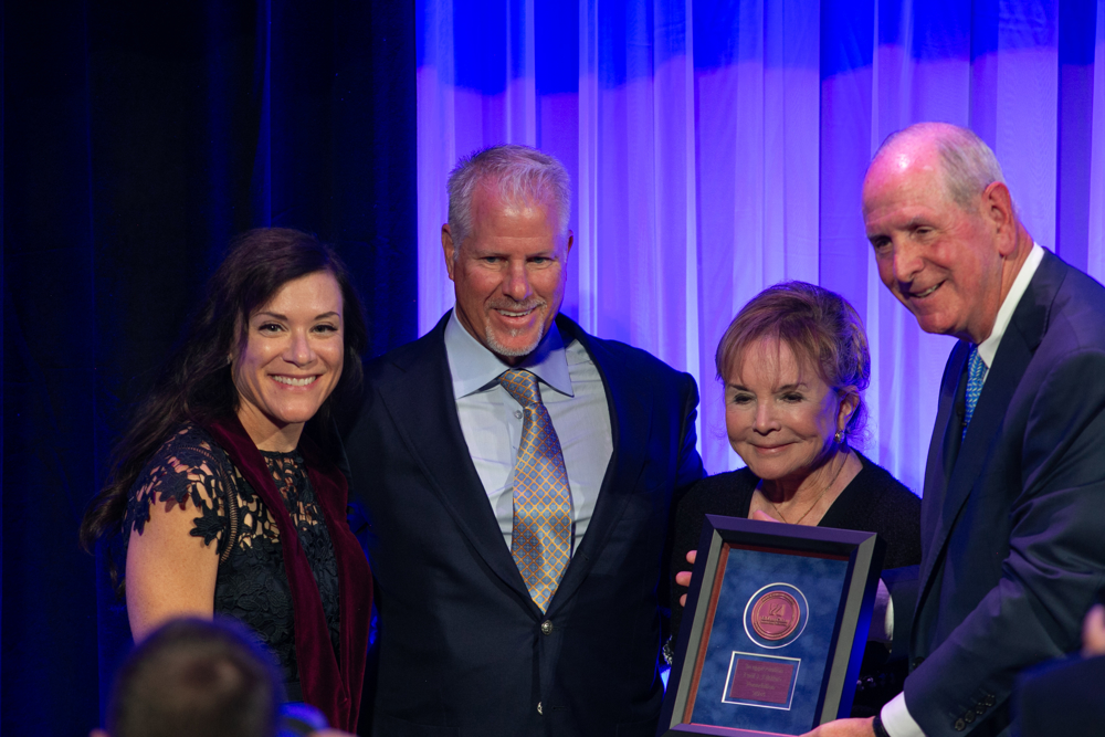 Chancellor Collins presents a medal to the Dimare family commemorating their endowment of the Paul J. DiMare Chair in n Neurodegenerative Disease. Pictured from left are Daryl Bosco, Tony DiMare, Swanee DiMare and Chancellor Collins.