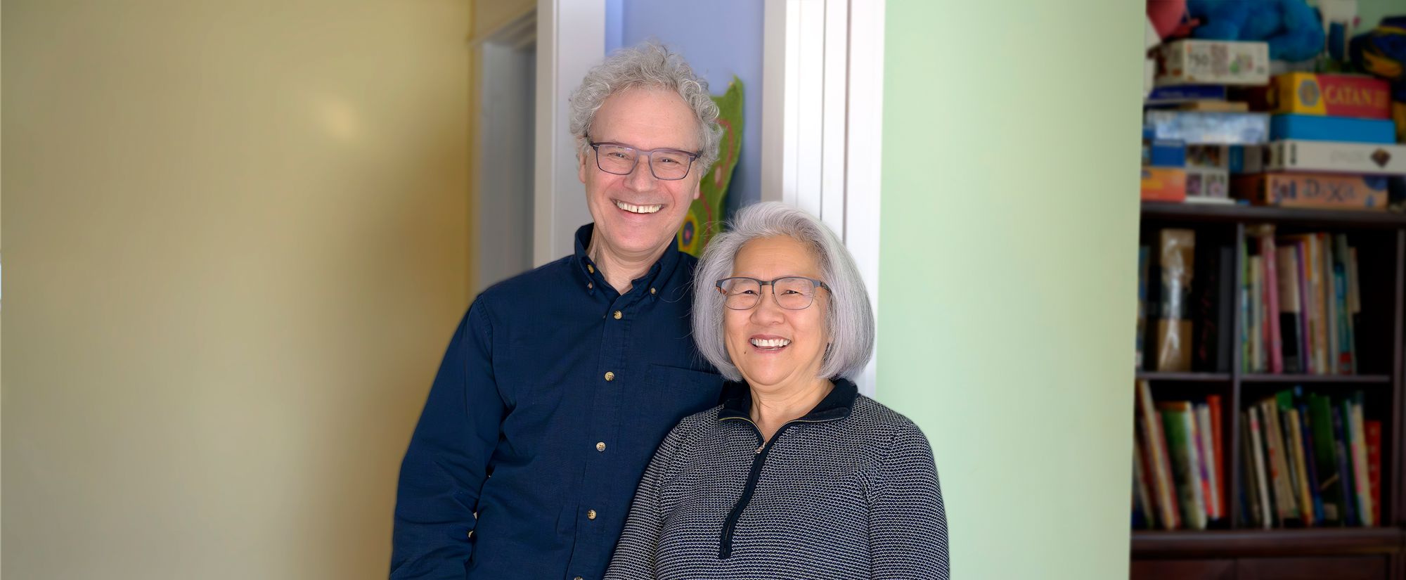 Photograph of Victor Ambros and Rosalind Lee standing side-by-side, smiling and looking into the camera.