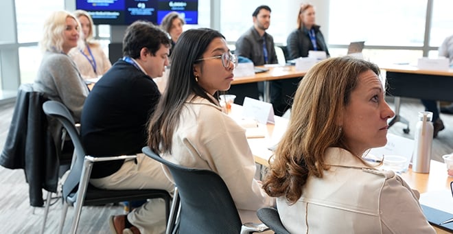 Participants sitting in chairs listening to session speakers