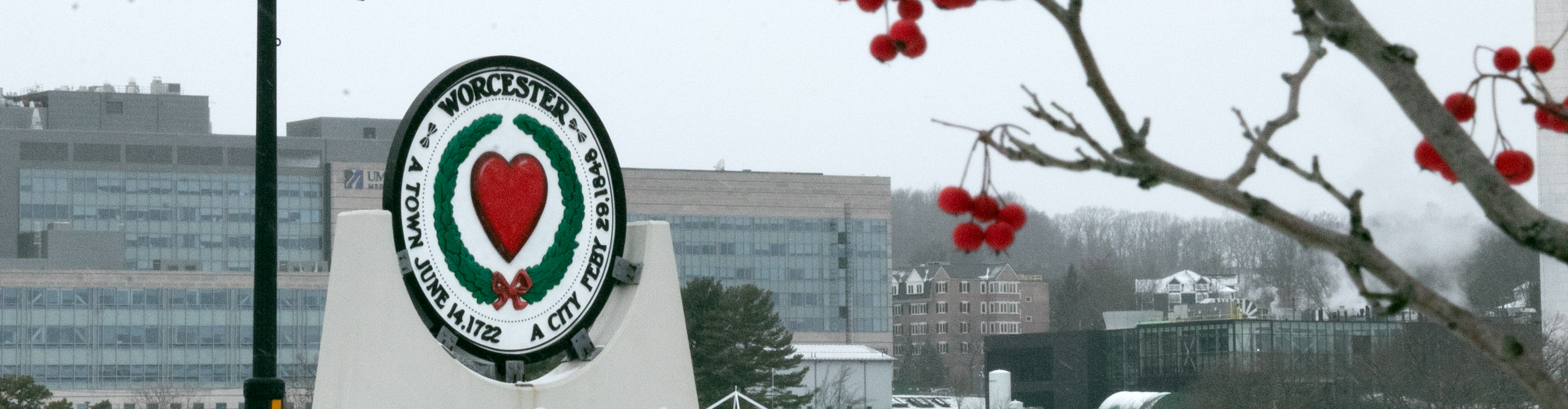 A winter view of campus featuring a circular sign that reads Worcester, A town June 14.1722, A city Feby 29.1848