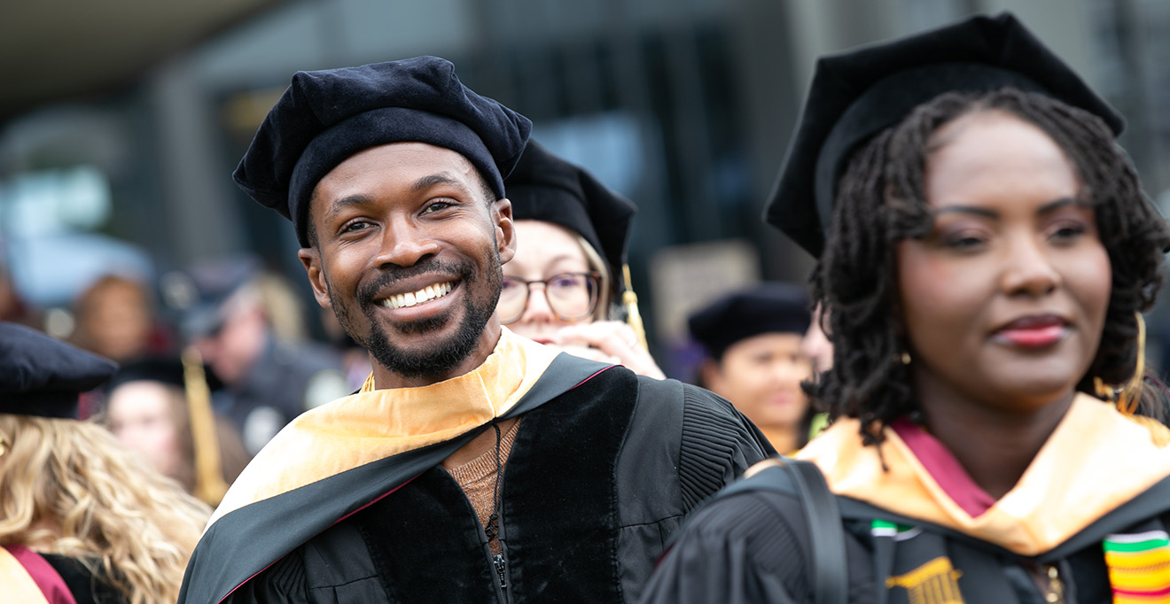 Photo of Daniel Appiah, DNP, walks with his fellow graduates of the Tan Chinfgen Graduate School of Nursing at UMass Chan