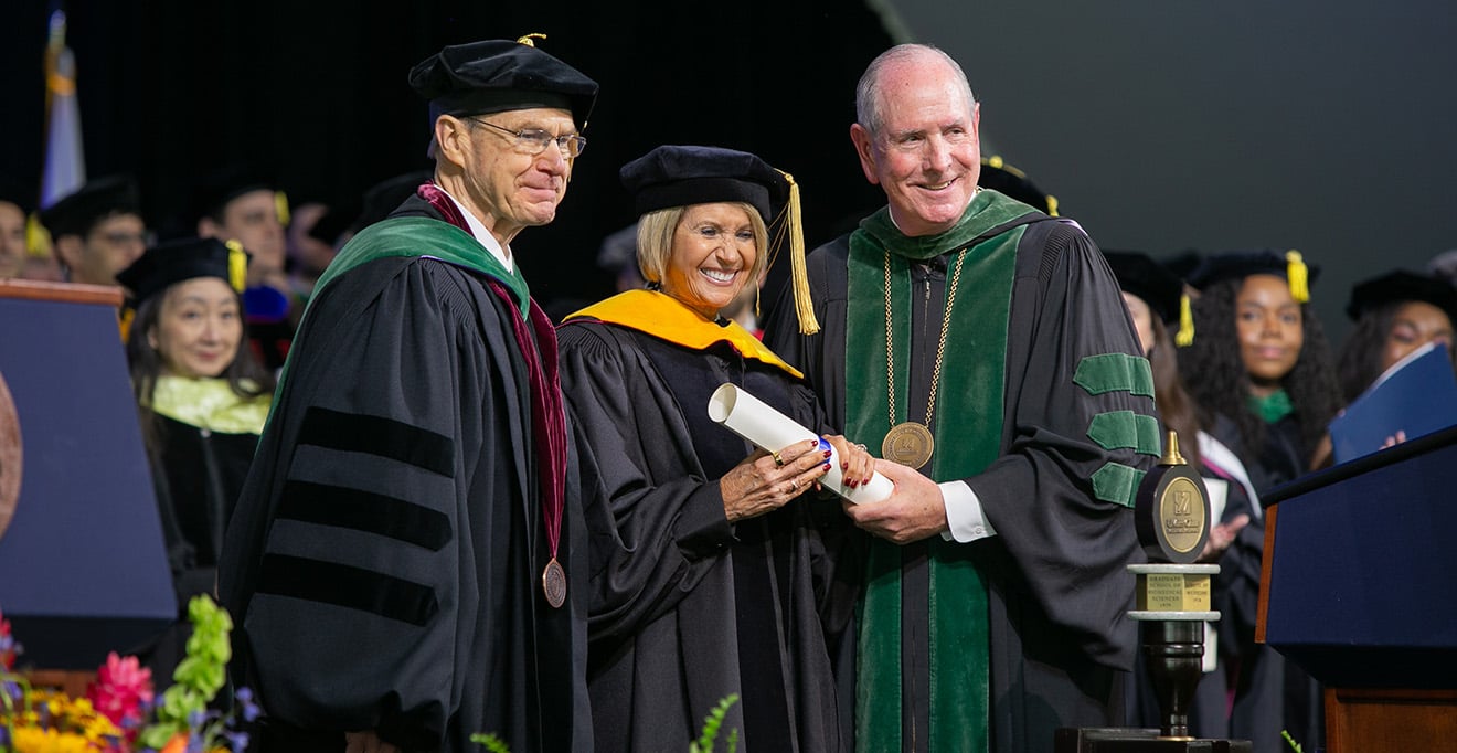 Photo of honorary degree recipient and Commencement speaker Marcia McNutt, PhD, flanked by Dean Terence R. Flotte and Chancellor Michael F. Collins