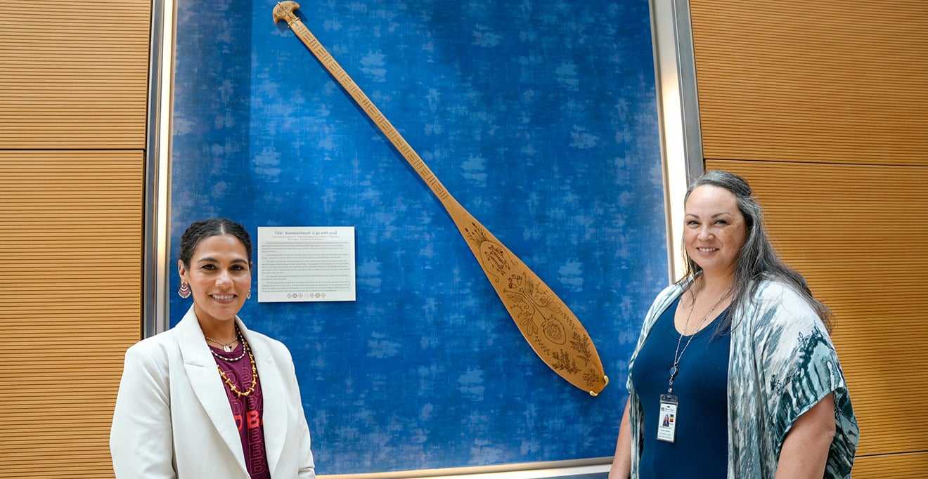 Kimberly Toney, MPP, and Jeanna Lee, PhD, in front of the paddle. 