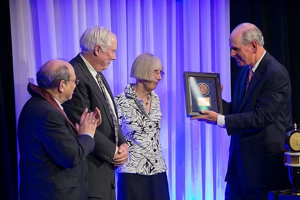 Neil Aronin (left) joins Chancellor Collins as he acknowledges Prentiss and Polly Higgins, who invested Aronin as the Higgins Family Professor of Neuroscience.