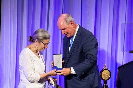 Dr Fingeroth accepts the medallion for her late husband, Robert Finberg, MD, from Chancellor Collins.