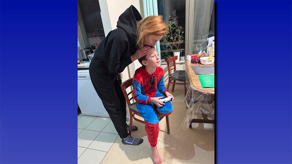 Tamara Radivilova kisses her son, Dmytrii, in their kitchen.