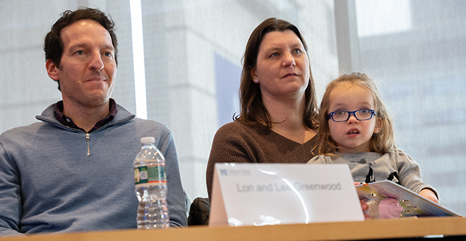 Four-year-old Noa Greenwood sits with her parents, Lee and Lori Greenwood at a conference room table